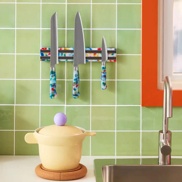 Colorful confetti-patterned kitchen knives and cutting board from Fredericks & Mae displayed on a white kitchen counter
