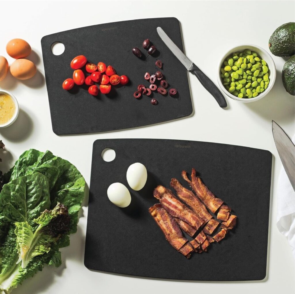 4 Cutting Board Materials — What Nobody Tells You Before Buying Four cutting boards made from stainless steel, bamboo, glass, and Epicurean composite material lined up on a kitchen counter