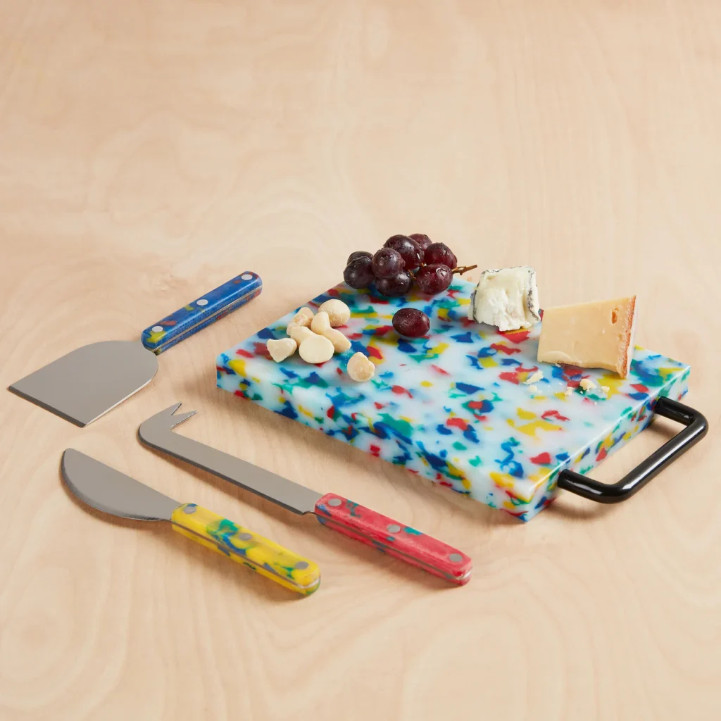 Colorful confetti-patterned kitchen knives and cutting board from Fredericks & Mae displayed on a white kitchen counter