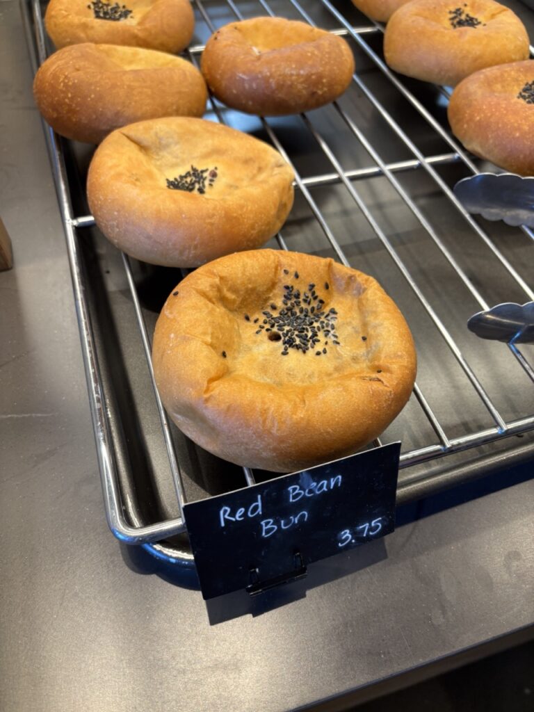 Close-up of soft Korean-style red bean bread with black sesame seeds on top