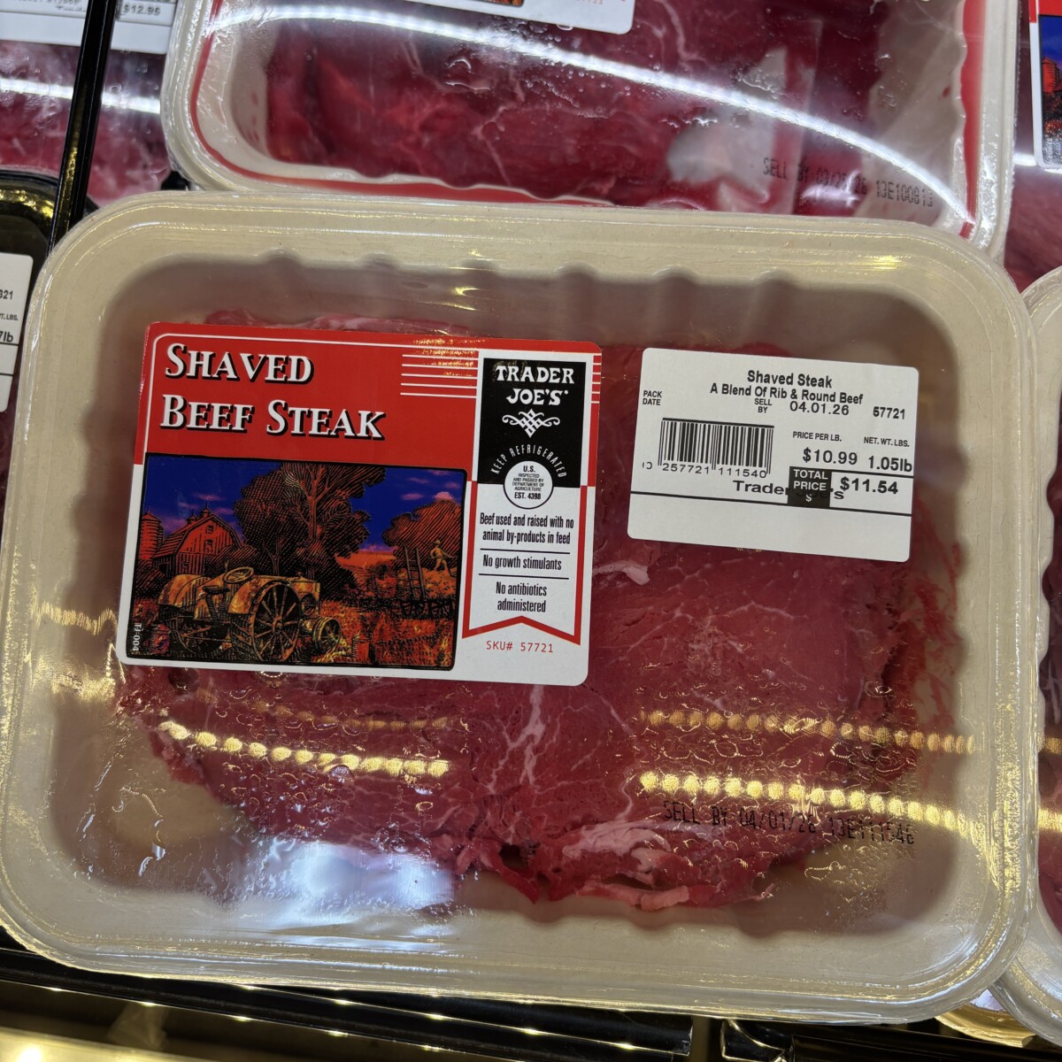 Two packages of Trader Joe's Shaved Beef Steak on a grocery store shelf, showing the blend of rib and round beef