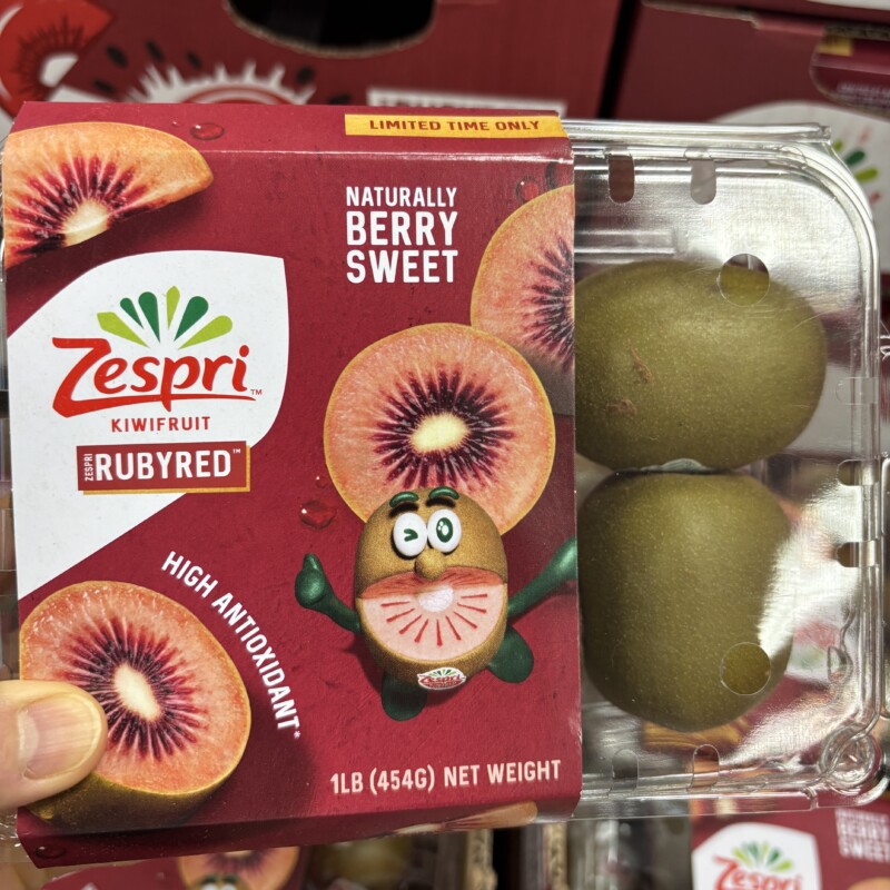 A package of Zespri RubyRed kiwifruit held up in a store, showing the ruby-red flesh on the packaging label, purchased at Trader Joe's in Edgewater, NJ